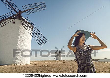 A young Chinese woman standing beside the famous windmills in Campo Criptana, where the stories of Don Quixote come from; Ciudad Real, Castile-La Mancha, Spain View Large Photo Image Stock Photograph - A young Chinese woman standing beside the famous windmills in Campo Criptana, where the stories of Don Quixote come from; Ciudad Real, Castile-La Mancha, Spain. Fotosearch