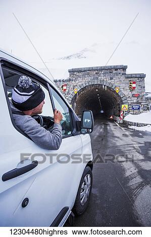 A young man looks out his window while driving at the highest point on Austria's highest mountain pass road, the Grossglockner High Alpine Road; Hochtor, Karnten, Austria View Large Photo Image Stock Photograph - A young man looks out his window while driving at the highest point on Austria's highest mountain pass road, the Grossglockner High Alpine Road; Hochtor, Karnten, Austria. Fotosearch