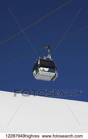 Stock Photograph - Aerial lift above the snow against the blue sky; Bagnes, Valais, Switzerland. Fotosearch