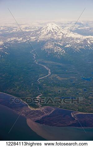 Stock Photograph - Aerial view of a river leading up to a snow-capped Mount Spur, Chigmit Mountains, Cook Inlet, Southcentral Alaska, USA.. Fotosearch