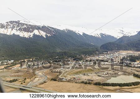 Stock Photograph - Aerial view of Glacier Highway towards the Juneau airport with snowcapped peaks in the background, Juneau, Southeast Alaska, USA, Spring. Fotosearch