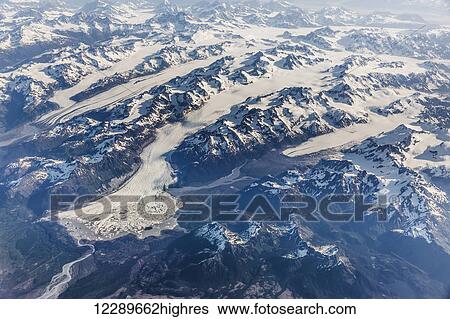Stock Photograph - Aerial view of snow covered mountains and glaciers in the Coastal Range, Southeast Alaska, USA, Summer. Fotosearch