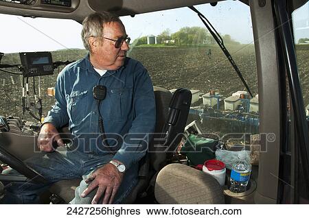 Agriculture - A farmer carefully monitors grain corn planting operations from the cab of his tractor. The tractor is guided by a GPS guidance system / near Northrop, Minnesota, USA. View Large Photo Image Stock Photograph - Agriculture - A farmer carefully monitors grain corn planting operations from the cab of his tractor. The tractor is guided by a GPS guidance system / near Northrop, Minnesota, USA.. Fotosearch