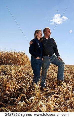 Agriculture - Farmer husband and wife pose together in a partially harvested grain corn field in Autumn / near Sioux City, Iowa, USA. View Large Photo Image Stock Photograph - Agriculture - Farmer husband and wife pose together in a partially harvested grain corn field in Autumn / near Sioux City, Iowa, USA.. Fotosearch