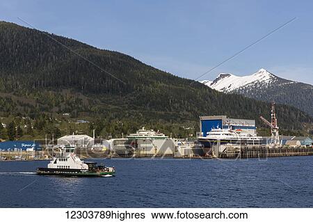 Stock Photograph - Airport passenger ferry passes in front of the waterfront docks and shipyards, Ketchikan, Southeast Alaska, spring. Fotosearch