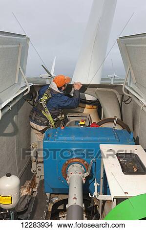 Alaska native technican checking for blade damage atop a wind turbine, St. Paul Island, Southwestern Alaska, USA, Summer View Large Photo Image Picture - Alaska native technican checking for blade damage atop a wind turbine, St. Paul Island, Southwestern Alaska, USA, Summer. Fotosearch