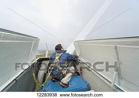 Alaska native technican checking for blade damage atop a wind turbine, St. Paul Island, Southwestern Alaska, USA, Summer View Large Photo Image Stock Photo - Alaska native technican checking for blade damage atop a wind turbine, St. Paul Island, Southwestern Alaska, USA, Summer. Fotosearch