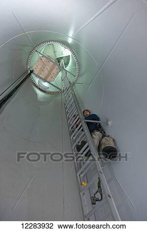 Alaska native wind turbine technican climbing a ladder inside the turbine, wearing a tool bag and harness, St. Paul Island, Southwestern Alaska, USA, Summer View Large Photo Image Stock Image - Alaska native wind turbine technican climbing a ladder inside the turbine, wearing a tool bag and harness, St. Paul Island, Southwestern Alaska, USA, Summer. Fotosearch