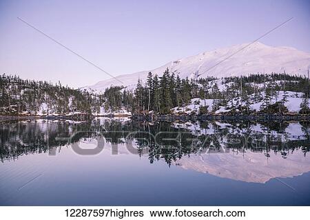 Stock Photograph - Alpenglow over Chugach mountains and Kings Bay, Prince William Sound, Whittier, Southcentral Alaska, USA, Winter. Fotosearch