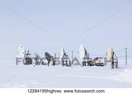 Stock Photograph - An array of satellite dishes pointing out to the Arctic Ocean, Barrow, North Slope, Arctic Alaska, USA, Winter. Fotosearch