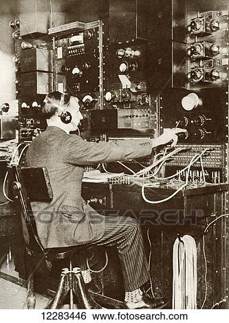 Stock Photograph - An English switchboard operator speaking to America by radio telephone for the first time in 1926. From The Story of 25 Eventful Years in Pictures published 1935. Fotosearch