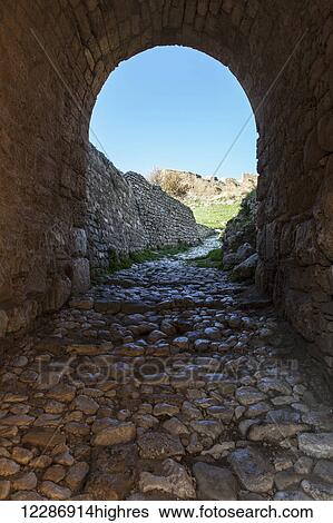 Stock Photograph - Arched tunnel with cobblestone ground, Upper Corinth; Corinth, Greece. Fotosearch