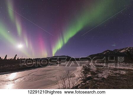 Aurora borealis and moon over frozen overflow and Alaska Range in Denali National Park & Preserve. View Large Photo Image Stock Photograph - Aurora borealis and moon over frozen overflow and Alaska Range in Denali National Park & Preserve.. Fotosearch