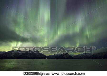 Stock Photograph - Aurora Borealis dancing above the Chugach Mountains and Turnagain Arm, Kenai Peninsula, Southcentral, Alaska. Fotosearch