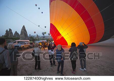 Stock Photograph - Balloons being inflated for sunrise balloon ride over Goreme National Park; Cappadocia, Turkey. Fotosearch