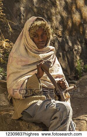 Beggar sitting on a rock; Ethiopia View Large Photo Image Stock Photograph - Beggar sitting on a rock; Ethiopia. Fotosearch