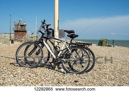 Bicycles parked on a shingle beach; Dungeness, Kent, England View Large Photo Image Stock Photography - Bicycles parked on a shingle beach; Dungeness, Kent, England. Fotosearch