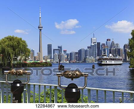 Stock Photo - Binoculars and skyline with Toronto Island ferry from Centre Island; Toronto, Ontario, Canada. Fotosearch