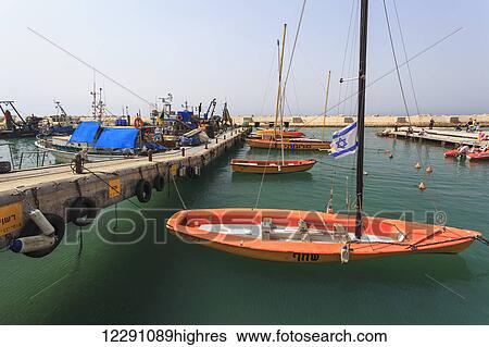 Stock Photograph - Boats in the turquoise water in the harbour; Joppa, Israel. Fotosearch