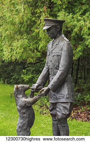 Stock Photograph - Bronze statue of Winnie the Pooh with Lieutenant Harry Colebourn in Assiniboine Park; Winnipeg, Manitoba, Canada. Fotosearch