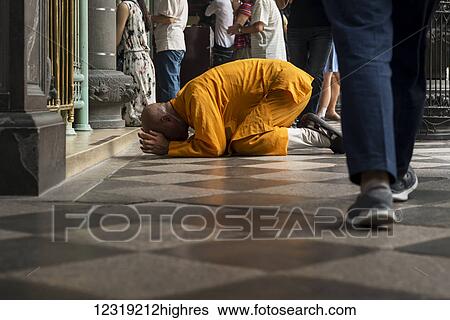 Stock Photograph - Buddhist Longshan temple in the city center of Taipei, a monk praying; Taipei, Taiwan, China. Fotosearch