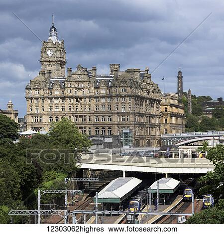 Stock Photograph - Building with clock tower and railway tracks; Edinburgh, Scotland. Fotosearch