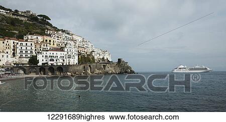 Stock Photograph - Buildings and a boat along the Amalfi coast; Amalfi, Campania, Italy. Fotosearch