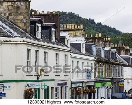 Stock Photograph - Buildings with shops and chimneys on the rooftops in a row; Dunkeld, Perth and Kinross, Scotland. Fotosearch
