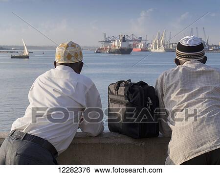 Businessmen watching ships in the harbour; Dar es Salaam, Tanzania View Large Photo Image Stock Photograph - Businessmen watching ships in the harbour; Dar es Salaam, Tanzania. Fotosearch