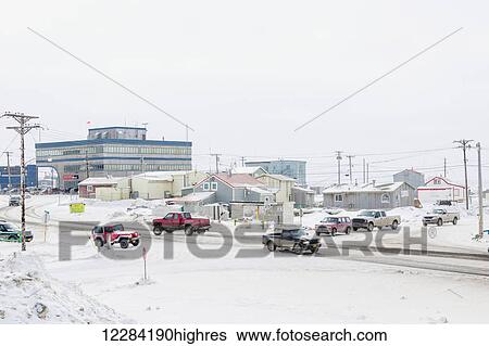 Stock Photograph - Cars and trucks drive on snow covered road in downtown Barrow, North Slope, Arctic Alaska, USA, Winter. Fotosearch