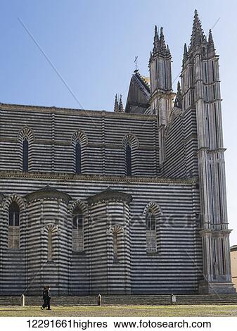 Stock Photograph - Cathedral of Orvieto with ornate peaks and a striped facade; Orvieto, Umbria, Italy. Fotosearch