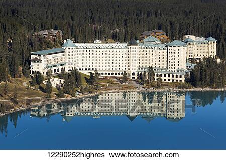 Stock Photograph - Chateau Lake Louise reflected in the tranquil intense blue mountain lake; Lake Louise, Alberta, Canada. Fotosearch
