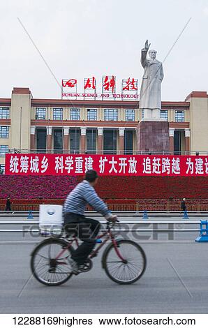 Chinese Man Riding Bicycle On The Street While Mao Zedong Statue Raises His Hand Chengdu Sichuan Province China Stock Photograph highres Fotosearch