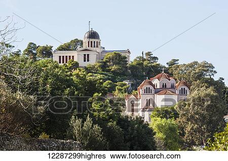 Stock Photograph - Church buildings on a hill surrounded by trees; Athens, Greece. Fotosearch