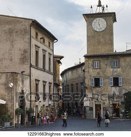 Clock tower and pedestrians outside of shops; Orvieto, Umbria, Italy View Large Photo Image Stock Photograph - Clock tower and pedestrians outside of shops; Orvieto, Umbria, Italy. Fotosearch