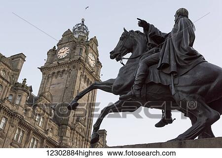 Stock Photograph - Clock tower of Balmoral Hotel and an equestrian statue of a horse and rider; Edinburgh, Scotland. Fotosearch