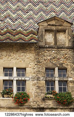 Stock Photograph - Close up of a coloured tile roof and windows in a village building,; Saint Antoine l'abbaye, Isere, France. Fotosearch