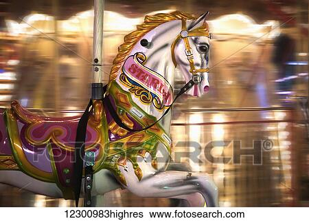 Stock Photograph - Close up of a painted horse on a carousel with blurred lights in the background; Sunderland, Tyne and Wear, England. Fotosearch