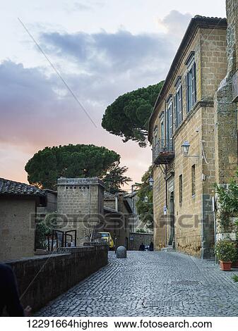 Cobblestone street by a residential building at sunset; Orvieto, Umbria, Italy View Large Photo Image Stock Photograph - Cobblestone street by a residential building at sunset; Orvieto, Umbria, Italy. Fotosearch