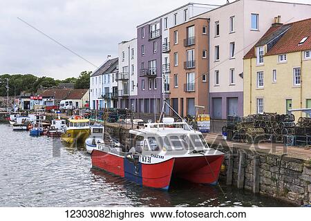 Colourful buildings at the waterfront and fishing boats moored in St. Andrews harbour; St. Andrews, Fife, Scotland View Large Photo Image Stock Photograph - Colourful buildings at the waterfront and fishing boats moored in St. Andrews harbour; St. Andrews, Fife, Scotland. Fotosearch