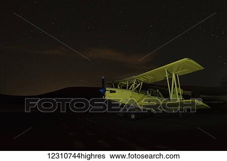 Stock Photograph - Crop duster flying in the dark; Palouse, Washington, United States of America. Fotosearch