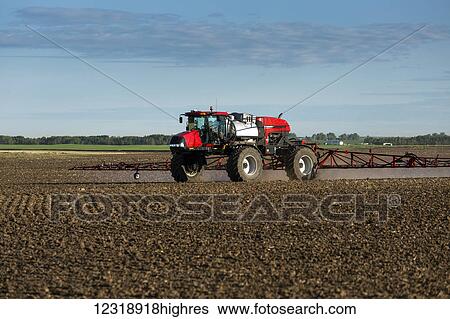 Crop sprayer in clean soil field with blue sky and clouds, East of Calgary; Alberta, Canada View Large Photo Image Stock Photograph - Crop sprayer in clean soil field with blue sky and clouds, East of Calgary; Alberta, Canada. Fotosearch