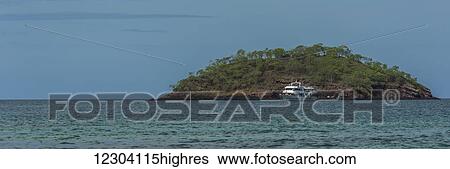 Cruiser anchored off island under blue sky; Galapagos Islands, Ecuador View Large Photo Image Stock Photograph - Cruiser anchored off island under blue sky; Galapagos Islands, Ecuador. Fotosearch