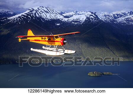 Stock Photograph - DeHavilland Beaver floatplane over East Behm Canal in Southeast Alaskas Misty Fjord National Monument. Fotosearch