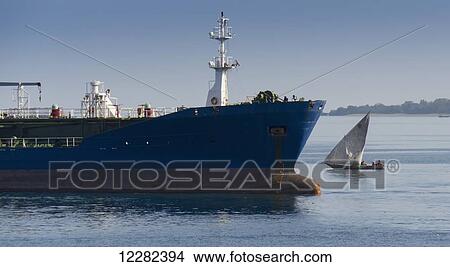 Picture - Dhow beside large ship; Zanzibar, Tanzania. Fotosearch