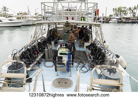 Stock Photograph - Divemasters working for Jack's Diving Locker giving the shaka hand sign while setting up the dive boat M/V Kea Nui for the next scuba diving trip in Honokohau Harbor; Island of Hawaii, United States of America. Fotosearch