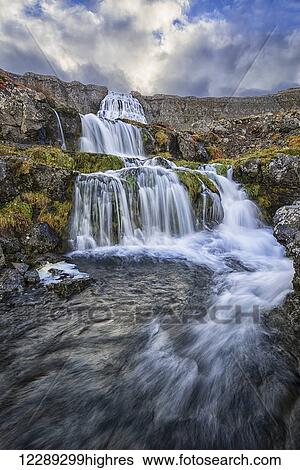 Dynjandi is one of the largest waterfalls in Iceland, consisting of seven different waterfalls that flow down the cascades on its way to the Atlantic Ocean, Iceland View Large Photo Image Stock Photograph - Dynjandi is one of the largest waterfalls in Iceland, consisting of seven different waterfalls that flow down the cascades on its way to the Atlantic Ocean, Iceland. Fotosearch