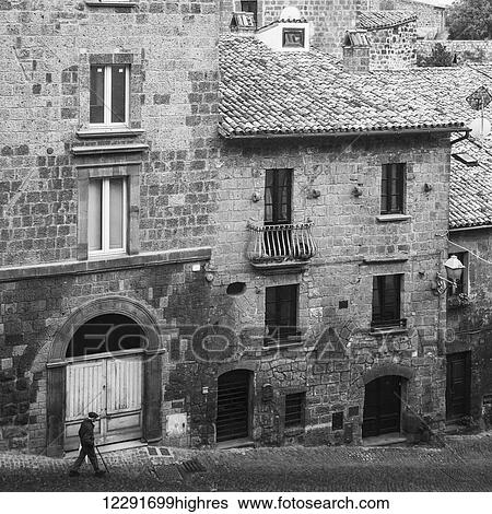 Elderly man with can walks down a cobblestone street beside stone residential buildings; Orvieto, Umbria, Italy View Large Photo Image Stock Photograph - Elderly man with can walks down a cobblestone street beside stone residential buildings; Orvieto, Umbria, Italy. Fotosearch