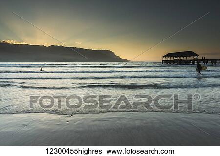 Stock Photograph - Evening sun over Hanalei Bay and pier; Kauai, Hawaii, United States of America. Fotosearch