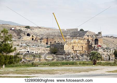 Stock Photograph - Excavation of the ruins of an ancient Greco-Roman theatre; Pamukkale, Turkey. Fotosearch